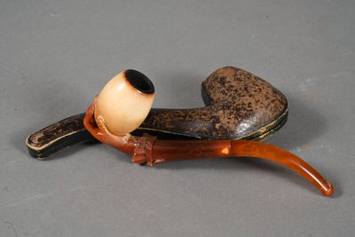 une pipe et un porte-pipe posés sur une table