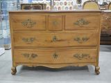 une commode en bois à nombreux tiroirs dans une pièce