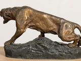 bronze statue of a lion on a rock on a table