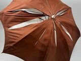 un parapluie marron ouvert sur fond blanc