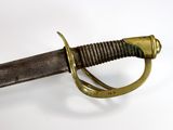 a close up of a sword on a white surface