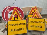 yellow and red signs sitting on top of a pile of construction materials