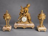 a gold clock with a statue on top of it