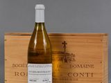 une bouteille de vin posée à côté d'une caisse en bois