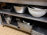de nombreux bols et casseroles sur l'étagère de la cuisine