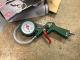 a green pressure gun and a gauge on a counter