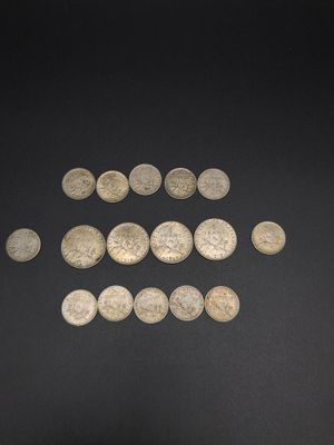 a close up of a pile of silver coins on a black surface