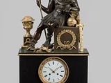 une statue d'un homme assis au sommet d'une horloge