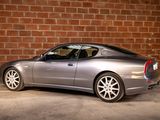 a silver sports car parked in front of a brick wall