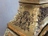 a gold clock with a bird on top of it