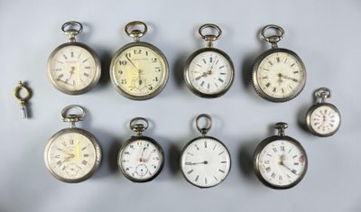 many different types of pocket watches displayed on a table