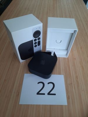 une Apple TV posée sur une table à côté d'un boîtier