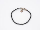 a black beaded bracelet with a skull charm