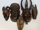 plusieurs masques africains accrochés au mur d'une pièce