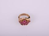 un gros plan d'une bague en or sertie de pierres roses
