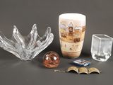 un vase en verre, un bougeoir en verre et une boule en verre posés sur une table