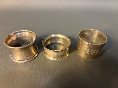 trois tasses en argent posées sur une table, l'une à côté de l'autre