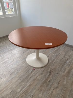 une table ronde avec un piètement blanc dans une pièce