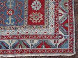 an image of a red, blue, and green rug on the ground