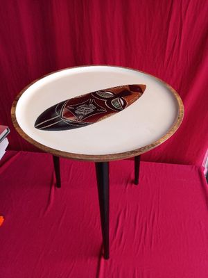 a small table with a surfboard on it on a red cloth