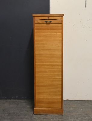 a tall wooden cabinet next to a black wall
