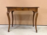 an old wooden table with a drawer on top of it
