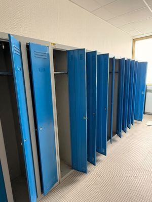 plusieurs casiers bleus sont alignés dans une pièce