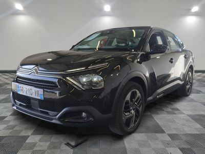 la voiture noire est garée sur un sol en damier dans le garage