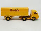 a yellow toy truck with a yellow trailer on a white surface