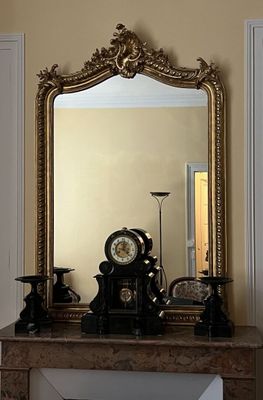 une cheminée surmontée d'une horloge, dans une pièce