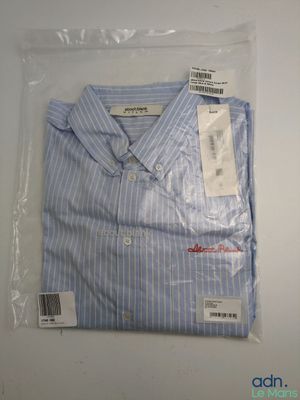 un gros plan sur une chemise dans un sac en plastique posé sur une table