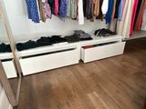 a picture of a closet with clothes hanging on a rail