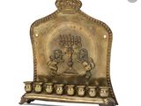 une plaque en laiton ouvragée sur laquelle figurent une menorah et cinq bougies