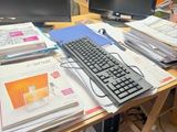 un homme debout devant un bureau équipé de deux écrans et d'un clavier