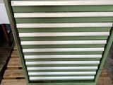 une armoire à outils verte posée sur une palette dans un garage