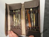 a person holding a leather case with a bunch of tools inside of it