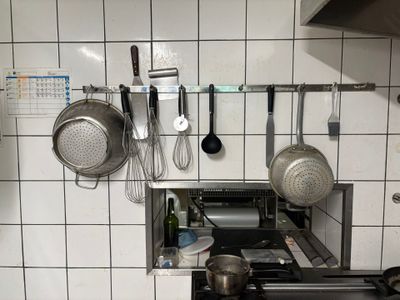 pots and pans are hanging on a wall in a kitchen
