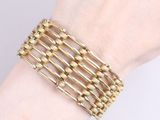 bracelet made of gold metal beads on a woman ' s wrist
