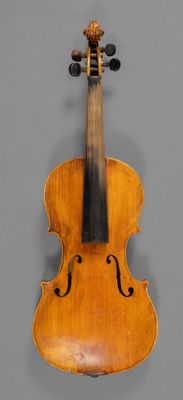 an old violin with a wooden back and bow on a gray background