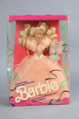 barbie doll in a box with a pink dress and gold hair