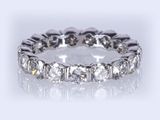 a close up of a diamond eternity ring on a white background