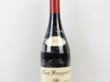 une bouteille de vin rouge posée sur une table blanche