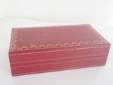a red box with a gold design on it sitting on a white surface