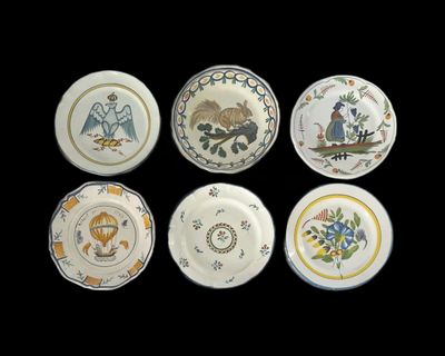 six assiettes ornées de motifs différents sur fond noir