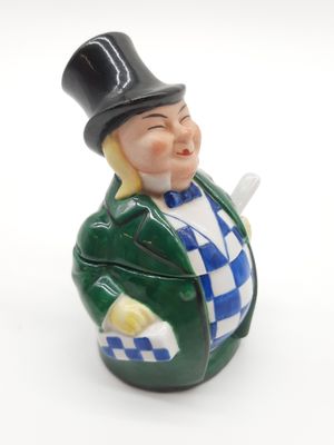 une figurine représentant un homme avec un haut-de-forme et une canne