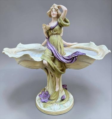 figurine of a woman holding a flower in her hand