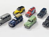 several toy cars are lined up in a row on a white surface
