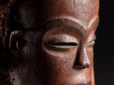 un gros plan d'un masque en bois orné de dreadlocks