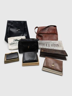 plusieurs types de sacs à main et de portefeuilles disposés sur une surface blanche