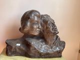 a statue of a man and a woman sitting on a rock